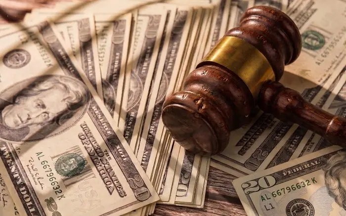 Judge's gavel on a pile of dollar bills