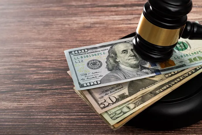 Judge's gavel resting on a stack of dollar bills