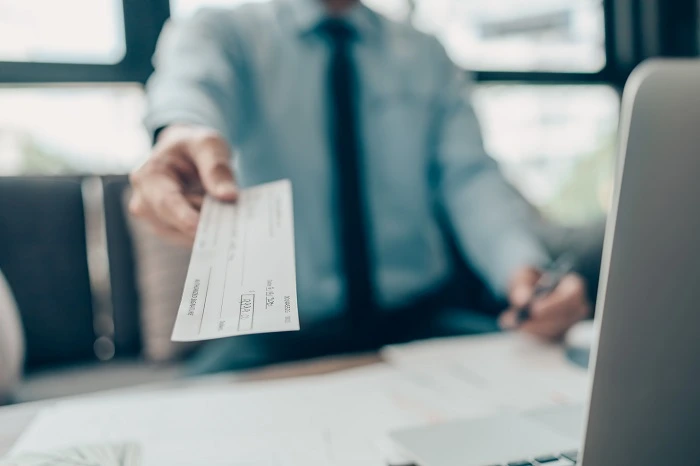Pasar un cheque por encima de un escritorio