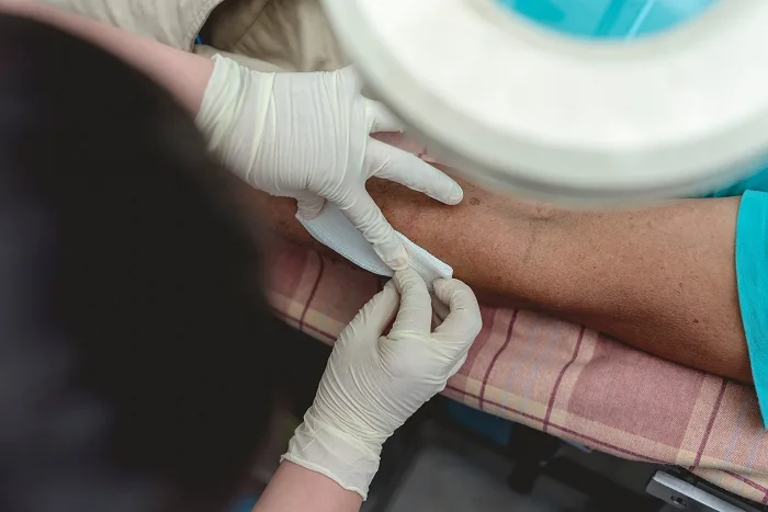Un trabajador sanitario venda una herida por mordedura en el brazo de un paciente.