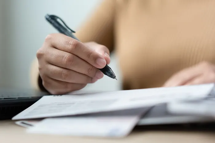 Hand signing legal papers with a pen